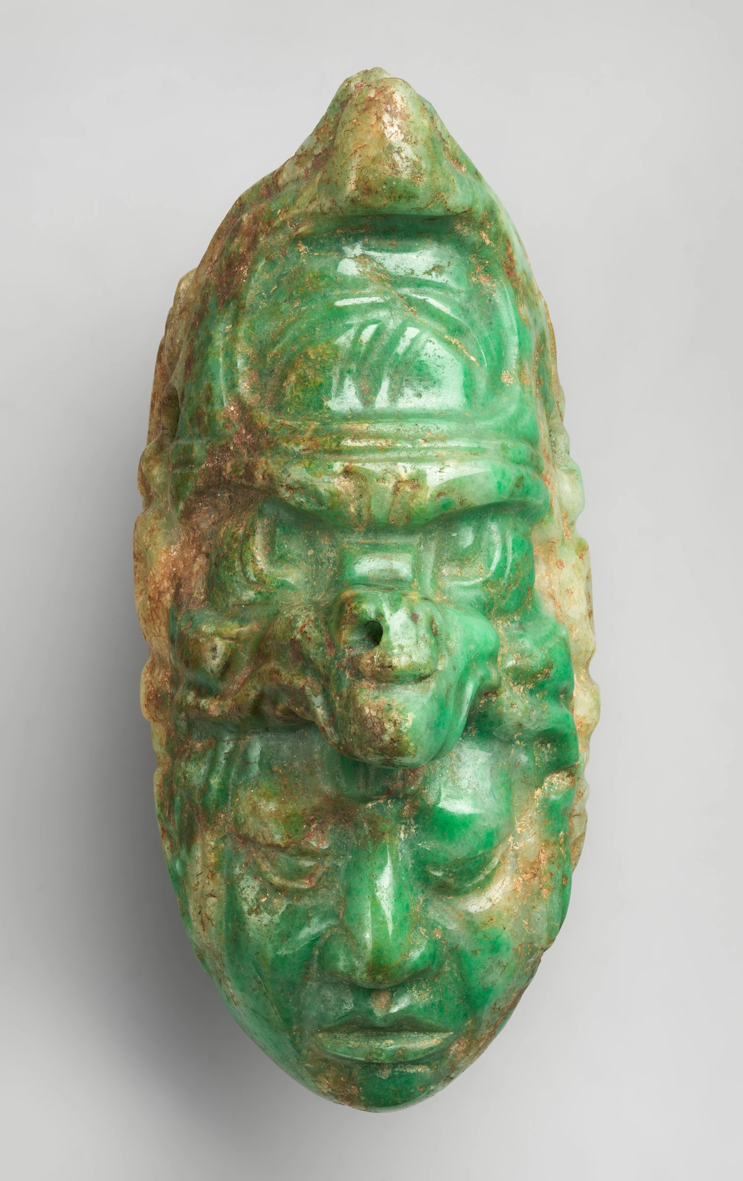 Jadeite pendant photographed against a neutral museum background